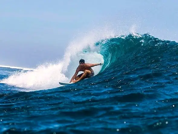 Gabriel dentro de um tubo numa onda azul em Lakey Pipe, na Indonésia
